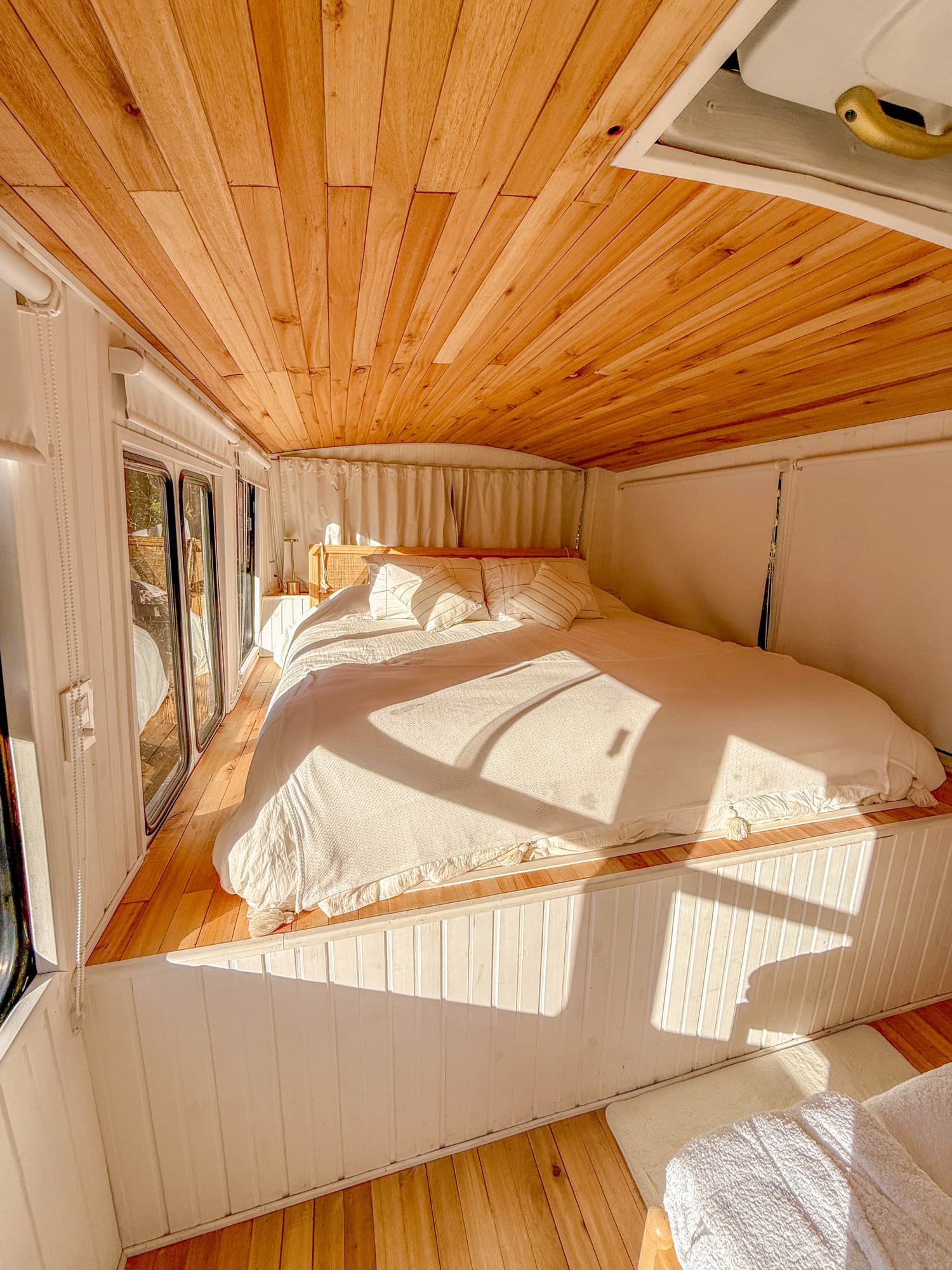 Detalle del dormitorio de BondiHouse con techo de madera y luz natural