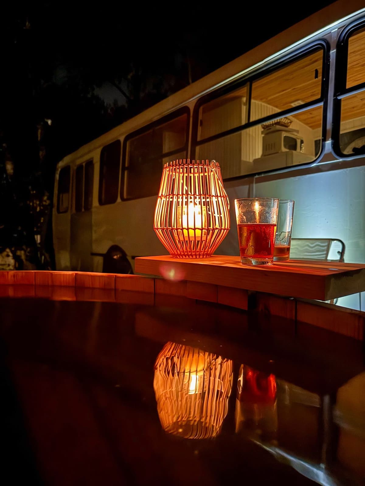La tina de noche, con un farol de velas y algo para tomar