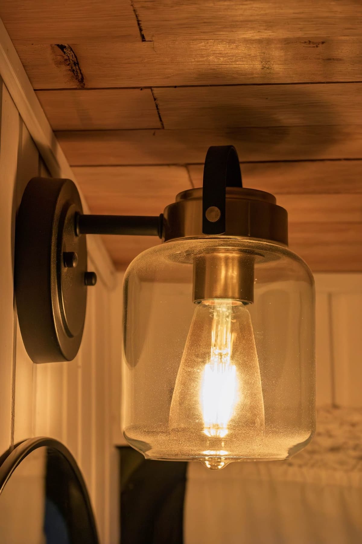 Aplique de pared con lamparita LED estilo Edison encendida en el baño del Bondi